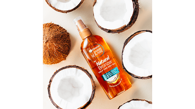 ambre-solaire-natural-bronzer-spray-at-angle-with-coconuts